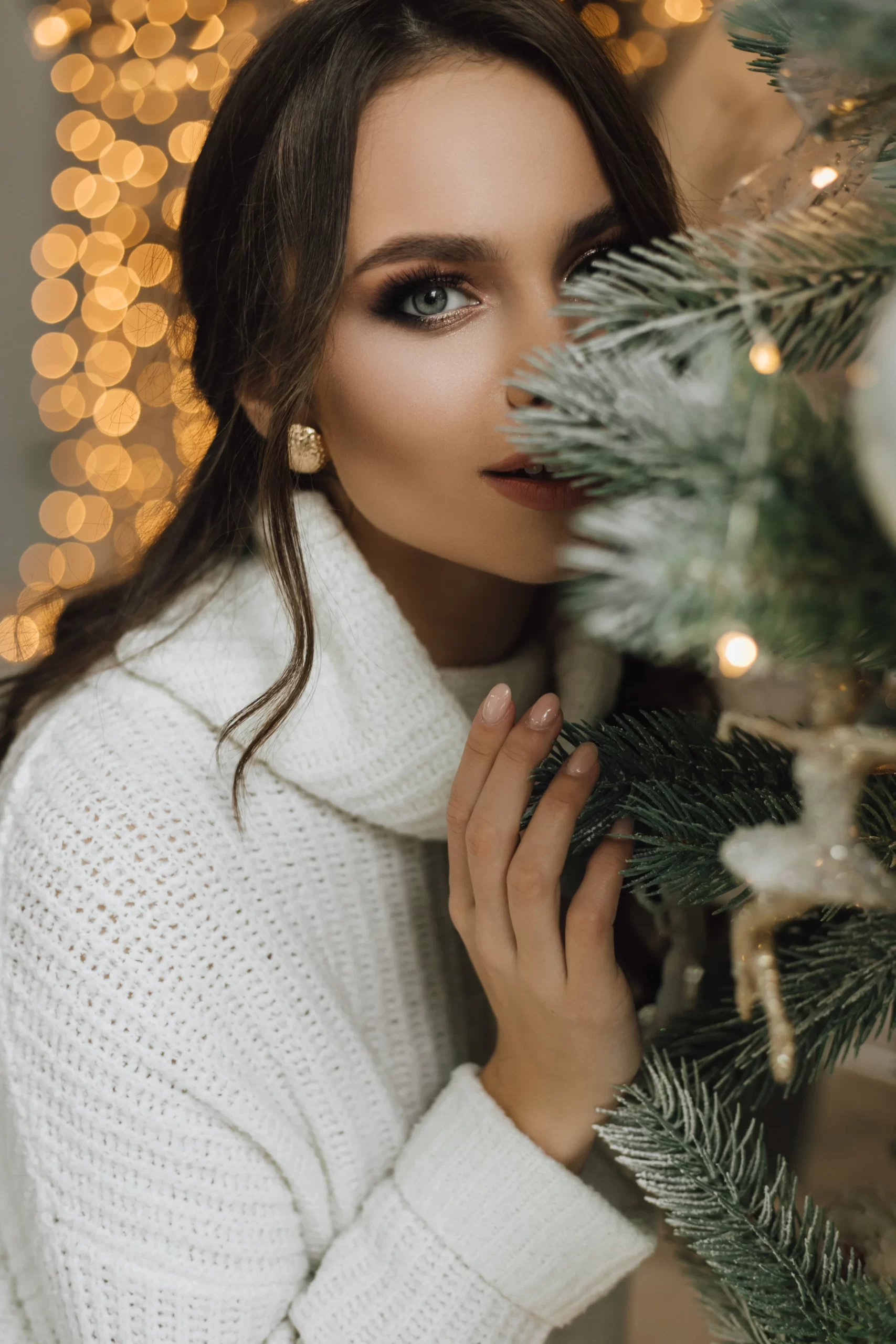 girl hiding behind christmas tree, half of face visible at uptown spa salon surrey